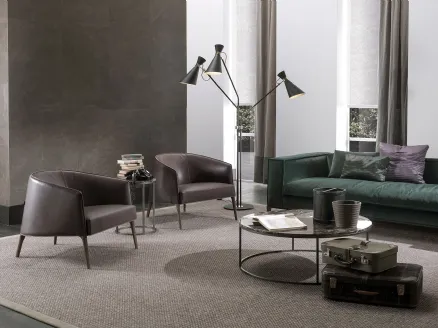 Jackie enveloping armchair in leather with solid wood feet by Frigerio.