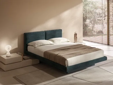 Blue upholstered bed with narrow storage box by Tagliabue Mobili.