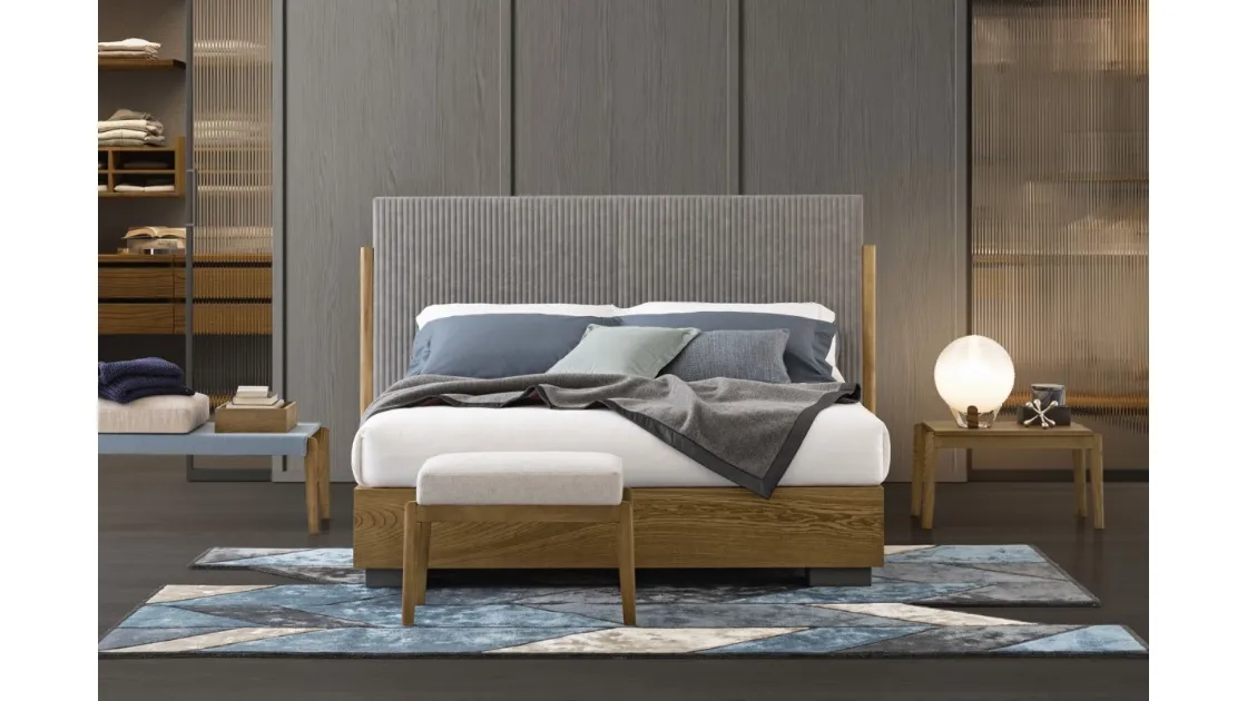 Bed with headboard upholstered in quilted fabric with side posts in solid Ash wood and base in Oggioni's Promenade wood.
