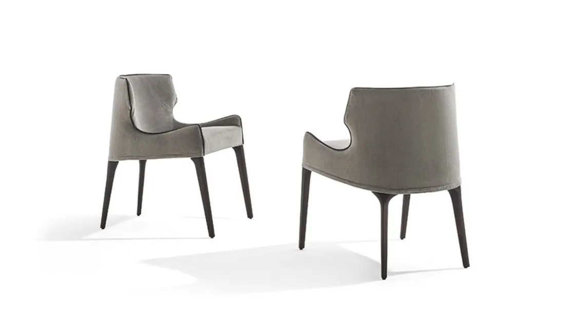 Wrap-around chair in padded fabric with solid wood Crosby legs by Frigerio.